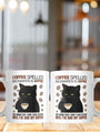 Two white ceramic coffee mugs with a grumpy black cat design