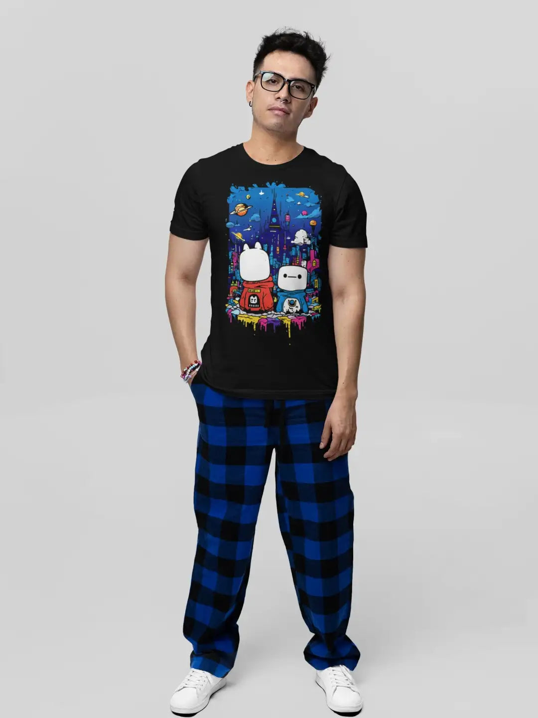 Men's black crew neck t-shirt with a colorful graphic print featuring two cartoon characters, paired with blue and black plaid pajama pants.