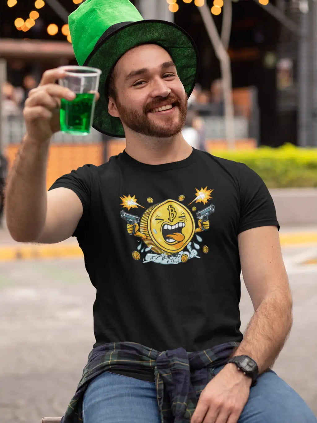 A man wearing a black t-shirt with a cartoon coin design and a green hat