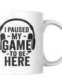 White ceramic mug with a black graphic of headphones and the text ’I PAUSED MY GAME TO BE HERE’