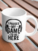 White ceramic mug with ’I PAUSED MY GAME TO BE HERE’ text and headphones graphic