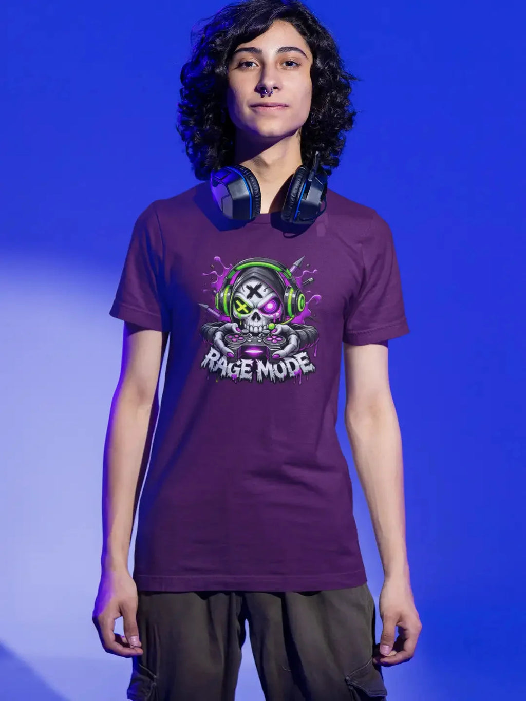 Purple short-sleeved t-shirt featuring a vibrant graphic of a skull wearing green headphones and holding a controller, with the text ’rage mode’ below